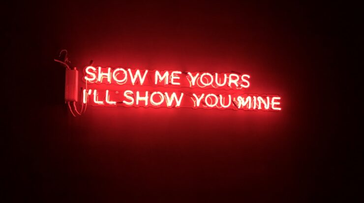 a neon sign saying: "Show me yours, I'll show you mine"